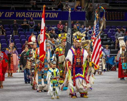 rows of dancers in traditional regalia at UW Hec Edmundson Pavilion