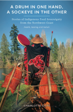 Cover photo of book showing woman wearing traditional Nhu-chah-nulth blanket, with arms raised, holding a drum