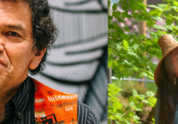 Roger Fernandes in orange sweater smiling at the camera and Barbara Lawrence holding her hand up to a tree outside