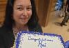 Kai holding a sheet cake that reads "Congratulations, Kai. 10 years at UW!" 