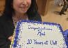 Kai holding a sheet cake that reads "Congratulations, Kai. 10 years at UW!" 