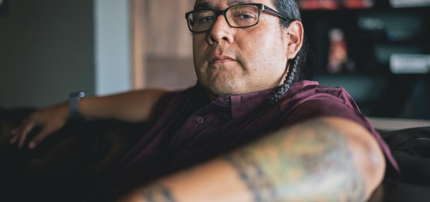 Oscar Hokeah sitting in an office armchair looking at the camera